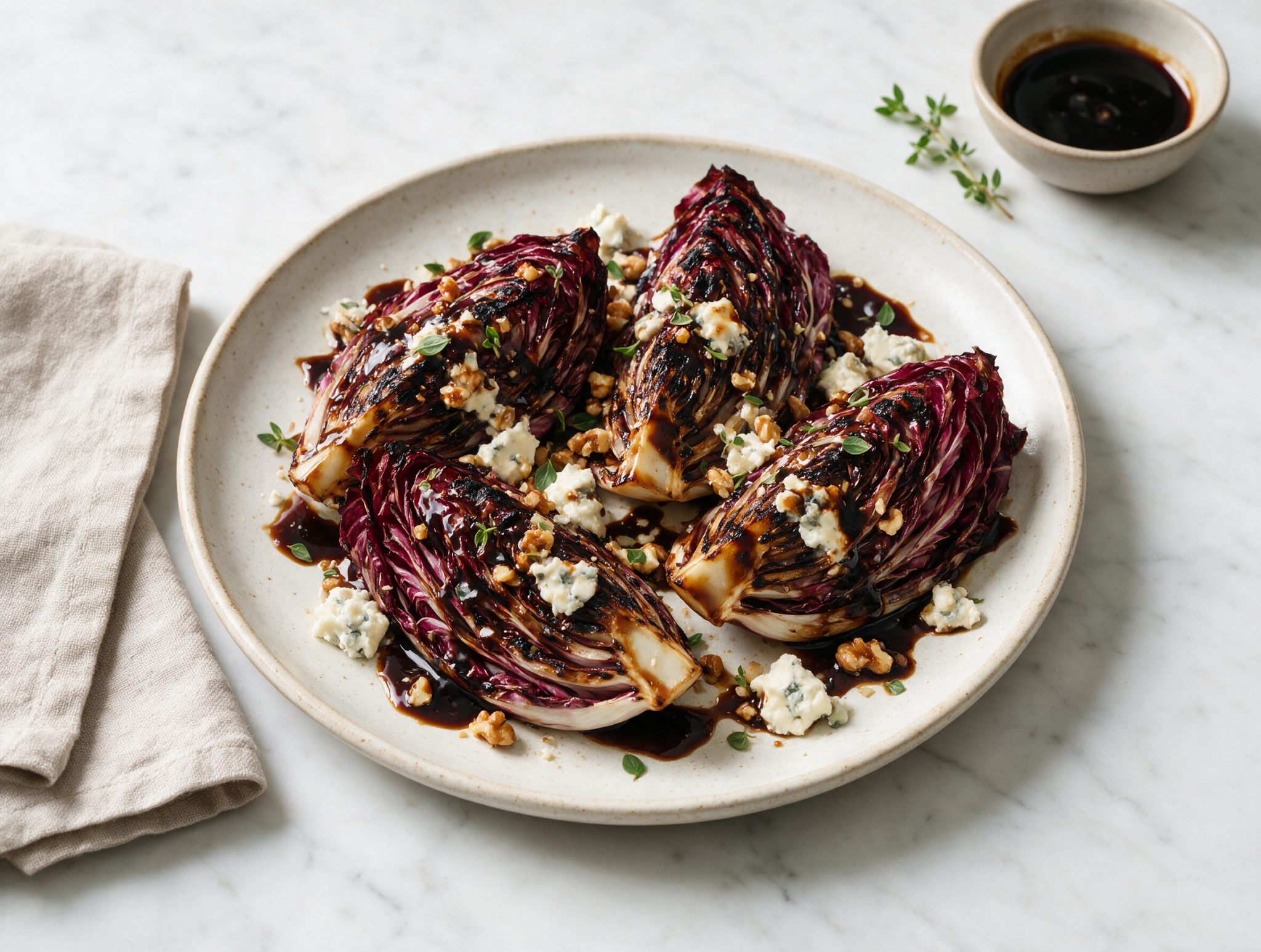 Charred radicchio wedges on a marble platter, balsamic glaze pooling with gorgonzola crumbles and walnuts.
